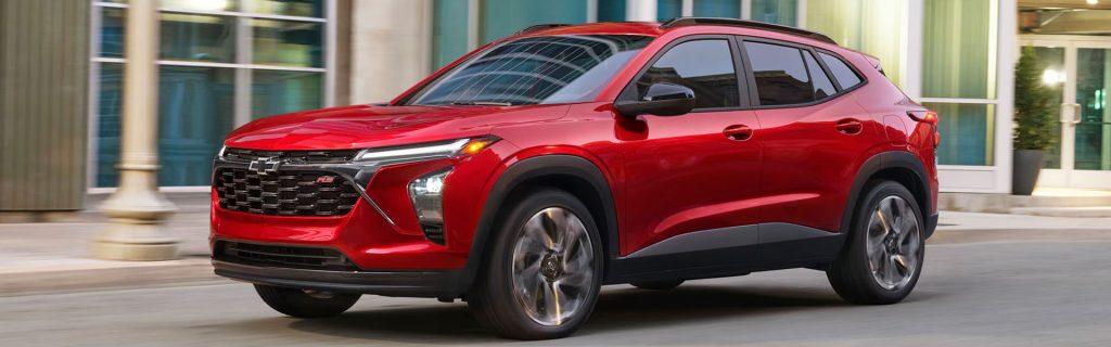 Refined exterior design of the 2026 Chevy Trax in motion through an urban setting.